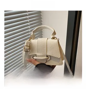 Close-up of litchi grain cream white handbag with gold-tone hardware and top handle