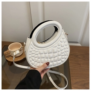 Close-up of white PU handbag featuring circular handle and embossed grid texture.