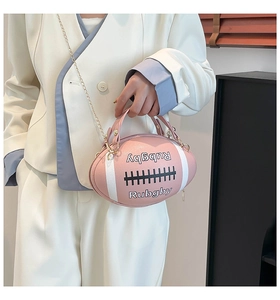 Close-up of pink rugby-shaped handbag with golden chain strap and white stripes