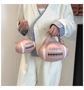 Close-up of pink rugby-shaped handbag with golden chain and matching mini pouch