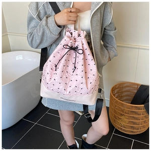 Detailed view of pink bow-print drawstring backpack with adjustable wide straps