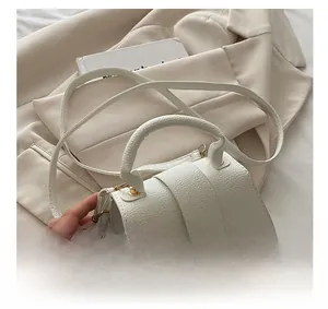 Detailed close-up of cream pebble-grain leather texture on this stylish handbag