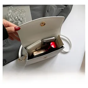 Detail view of the open flap crossbody bag showing internal space for phone and makeup
