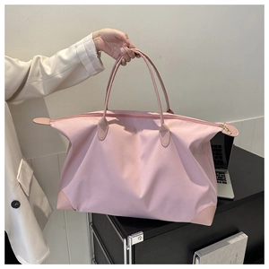 Bolso de viaje grande de nailon rosa sostenido por persona con chaqueta blanca