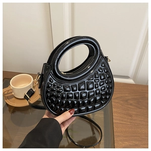 Fashionable black glossy handbag featuring unique 3D bubble texture and round top handle
