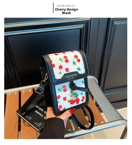 Detail of mini square crossbody bag featuring cherry print and black leather trim