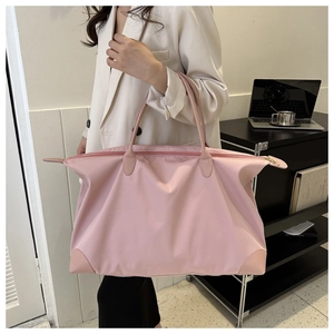 Modelo con una bolsa de viaje grande de nailon rosa ideal para viajes cortos y traslados
