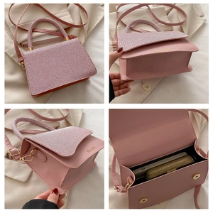 Dettagli di una borsa a tracolla rosa con manico superiore e trama intrecciata fine