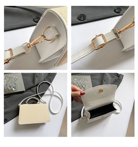 Detail view of woven straw bag with white leather trim and gold adjustable shoulder strap