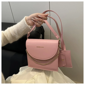 Détail du sac à main rose avec rabat, chaîne dorée et petit porte-monnaie assorti