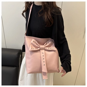 Detail of pink cloud bucket bag with large bow and silver metal rivet studs