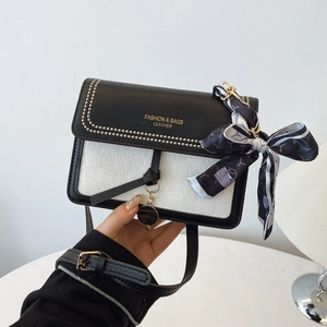 Detail of contrast crossbody bag with logo lettering and silk scarf on strap