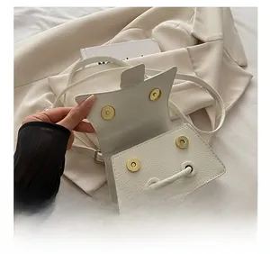 Detail of white litchi pattern leather bag showing premium gold magnetic closures