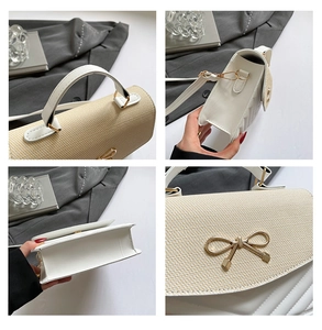 Detail view of woven flap with gold bow clasp on a white leather handbag for women