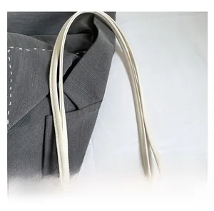 Dettaglio macro dei manici cuciti di alta qualità su una borsa tote color crema chic