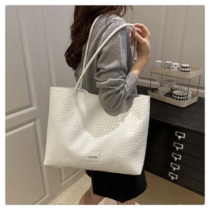 Detail of white woven texture on a large capacity tote bag with fashion label patch