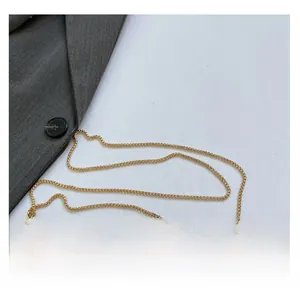 Close-up of golden metal woven chain strap with polished ring buckles on professional attire
