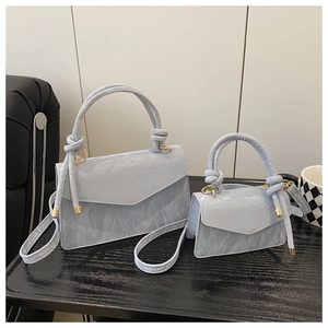 Detail of light blue handbag set with marble texture and elegant knotted handle design