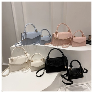 Detail view of stylish knotted handle bags in blue, pink, white, and black colors