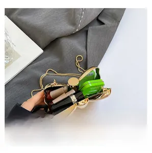 Detail view showing inner storage of the shell-shaped evening bag with a gold chain