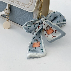 Detail of color-block crossbody bag with lychee texture leather and floral silk scarf