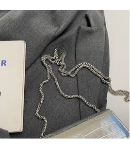 Detail of silver crocodile pattern leather handbag with metallic braided chain strap