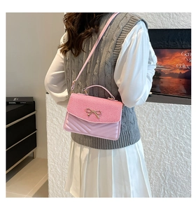 Pink shoulder bag featuring woven texture, V-quilt leather and a metal bow detail