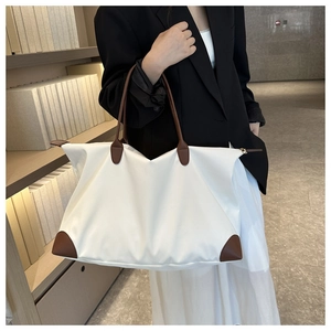 Gran bolso de viaje blanco con asas de cuero marrón para el viaje diario de mujer.