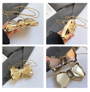 Dettaglio della clutch a fiocco dorata con doppi specchi interni e catenina