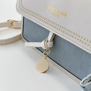 Detail showing high-quality stitching and golden text on white and blue leather bag