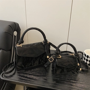 Chic black pleated shoulder bags set with gold hardware and knotted handle detail