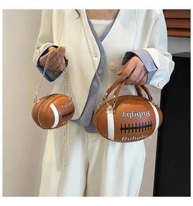 Detail of football-shaped PU leather bag with chain strap and white contrast stitching