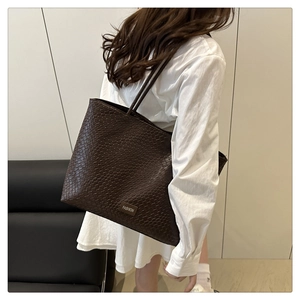 Close-up of the intricate woven texture and leather logo tag on this coffee tote bag