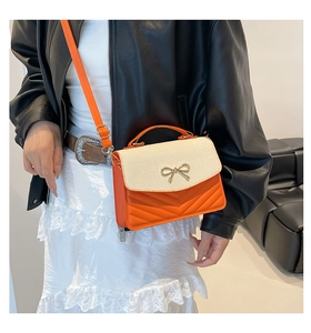 Chic orange quilted leather bag with woven flap and gold bow clasp detail