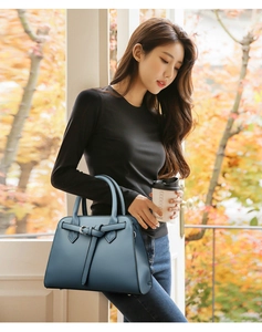 Close-up of greyish blue leather tote bag with lychee texture and buckle detail