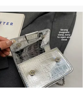 Detail view of silver crocodile embossed mini bag showing secure double magnetic closures