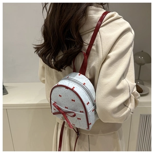 Mini white backpack with red bow print and large faux leather bow detail on model