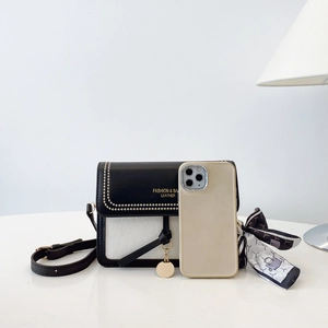 Detail of mini black and white leather crossbody bag with silk scarf and gold charm
