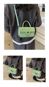 Detail of light green quilted handbag featuring a flower-shaped lock and gold hardware