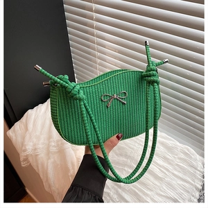 Detail of bright green woven hobo bag with silver metallic bow and knotted rope strap