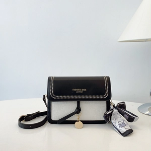 Detail of contrast square bag with adjustable strap and decorative geometric silk scarf