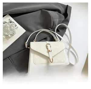 Detail of white leather handbag with snakeskin texture flap and gold metal clasp