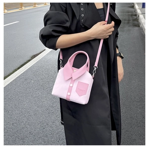 Detailed street shot of a unique pink shirt-shaped handbag with lapel and white buttons