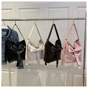 Detailed row of bow-knot shoulder bags with metal rivets in four stylish colors