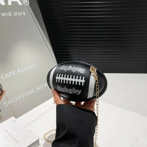 Black rugby shaped mini chain bag with white stripes and embossed texture held by hand