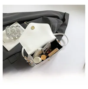 Interior view of white leather crossbody bag showing capacity for phone and cosmetics