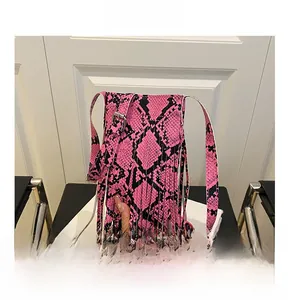 Macro view of pink and black snakeskin print leather with hanging fringe details