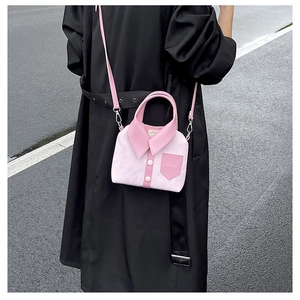 Pink shirt-shaped bag with collar and buttons shown on model in black coat