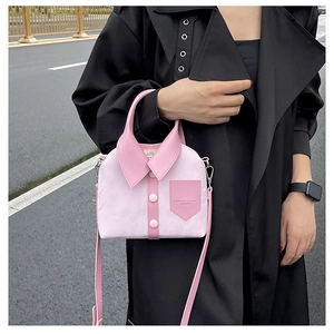 Detail of pink shirt-style handbag with lapel and button accents on black coat