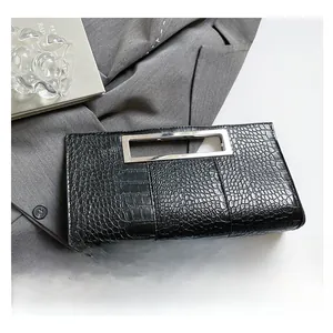 Close-up of black crocodile pattern clutch bag with silver rectangular metal handle
